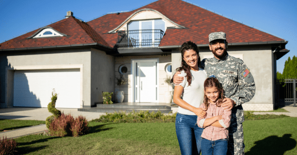 VA Loans: Military family standing proudly in front of their new home, symbolizing the benefits of homeownership made possible through VA loans.